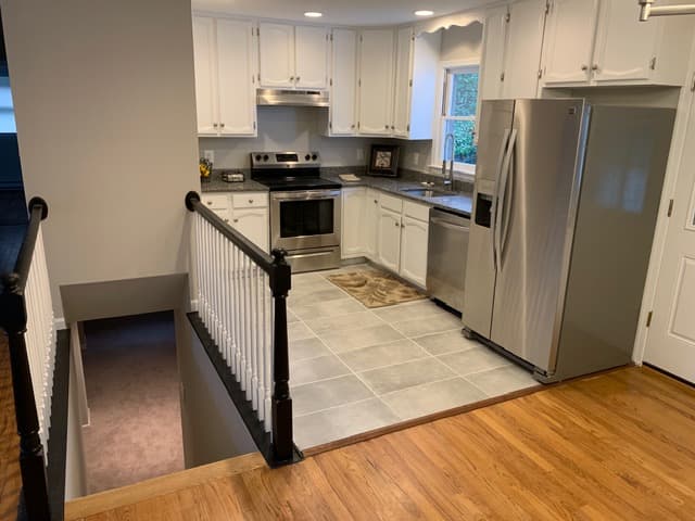 A completed kitchen renovation with new cabinetry, appliances, and flooring