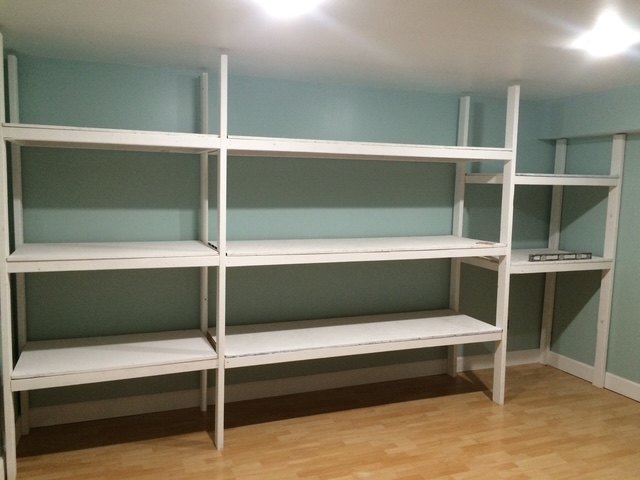 The same wall painted and fitted with a full run of white built-in shelving